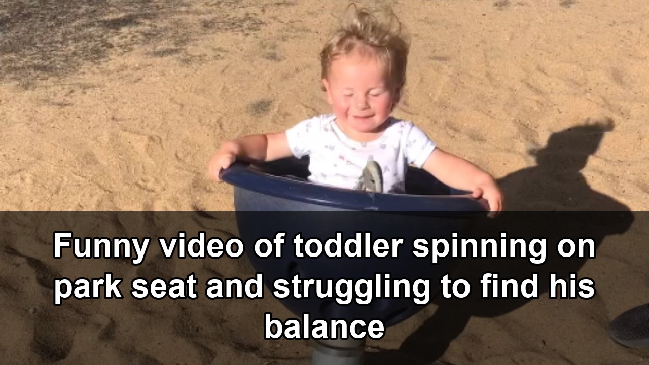 Toddler attempts to regain stability after spinning on park equipment